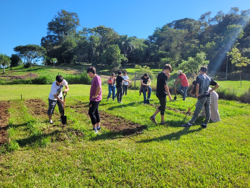 Alumnos cavando en la huerta